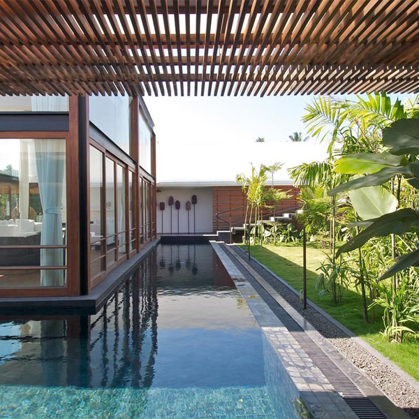 piscina rodeando vivienda acristalada