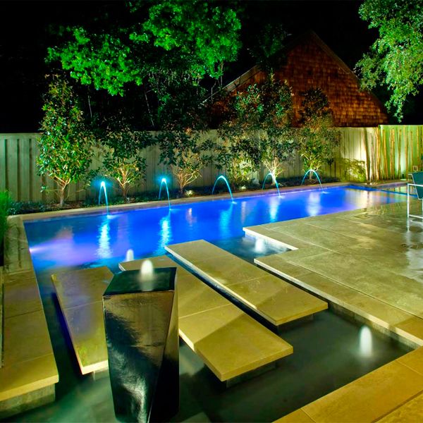 private pool, water features and garden at night, by Pool Environments
