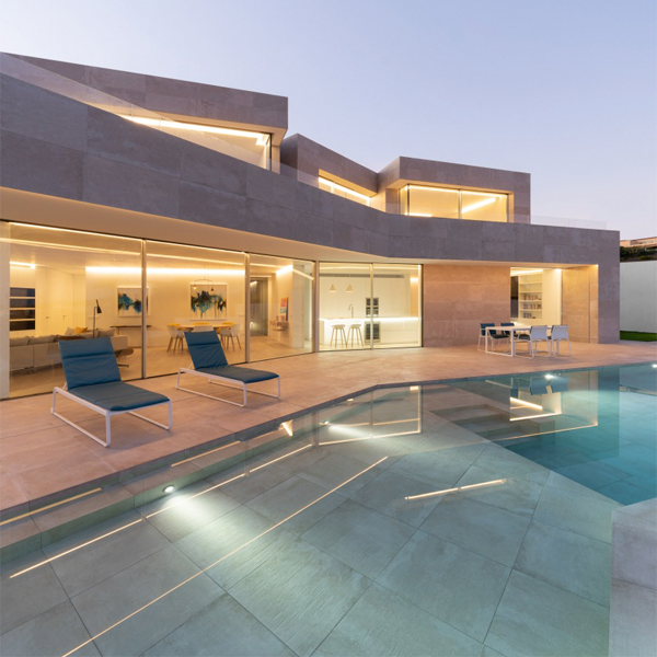 Large private infinity pool at night by Angel Fito Estudio