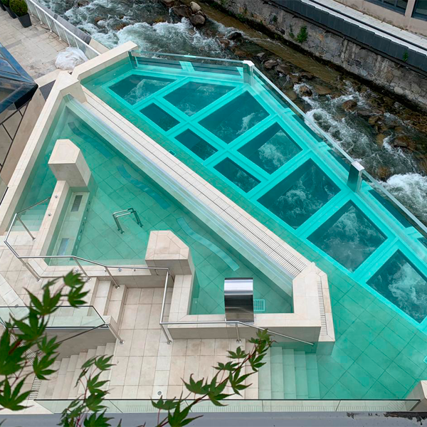 pool and spa with transparent floor by Piscinas Condal