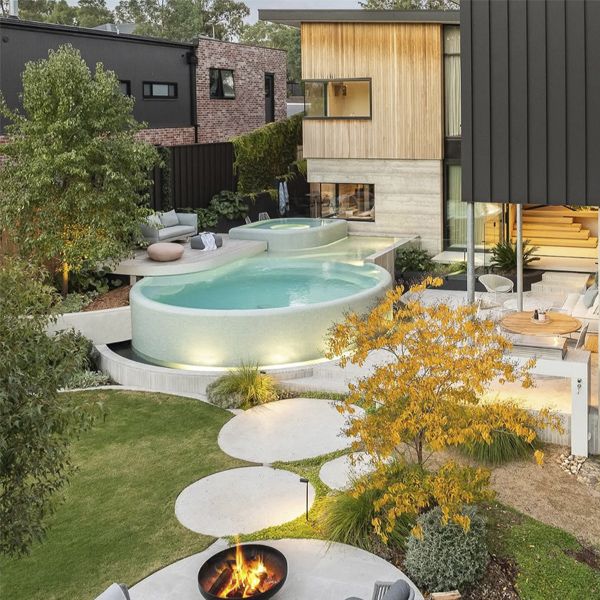 Round infinity pool, by TLC Pools, in a spectacular and modern garden, also with an overflowing spa