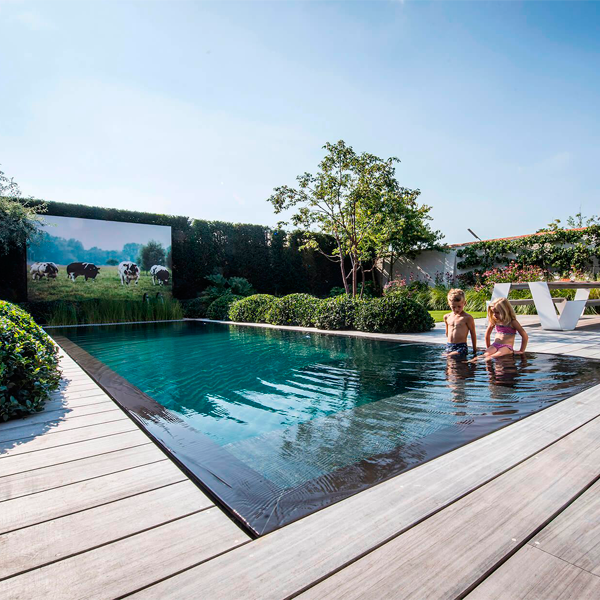 Piscina desbordante con entorno en madera y vegetación