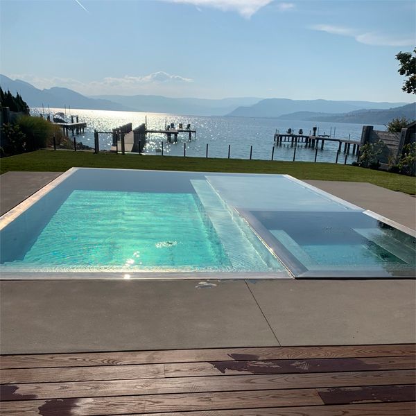 stainless steel infinity pool with built-in spa, by Pure Stainless Pools, with lake view