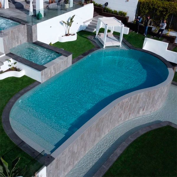 drone view of a 3-level custom infinity pool with built-in spa, by Exterior Piscines