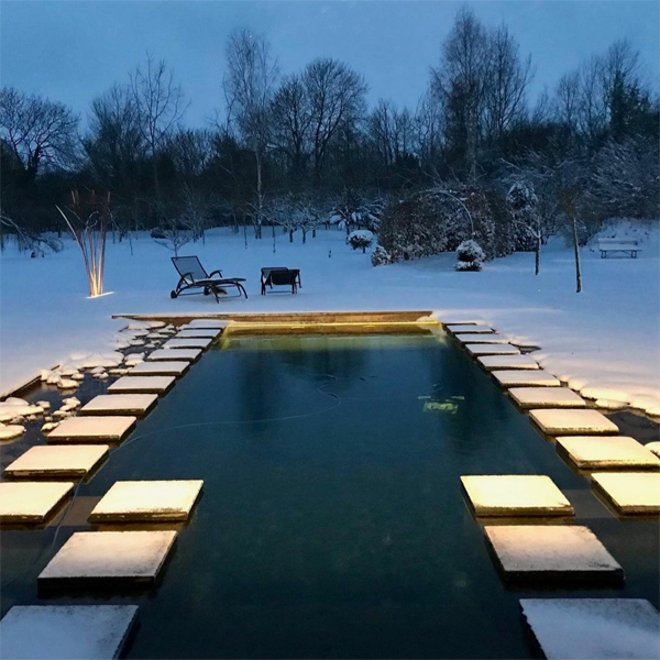 natural pool surrounded by snow at night