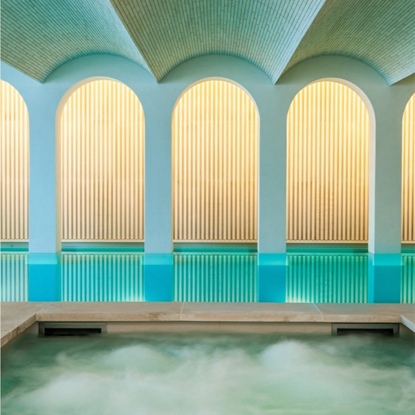 picina interior con zona spa y arcos decorativos en las paredes