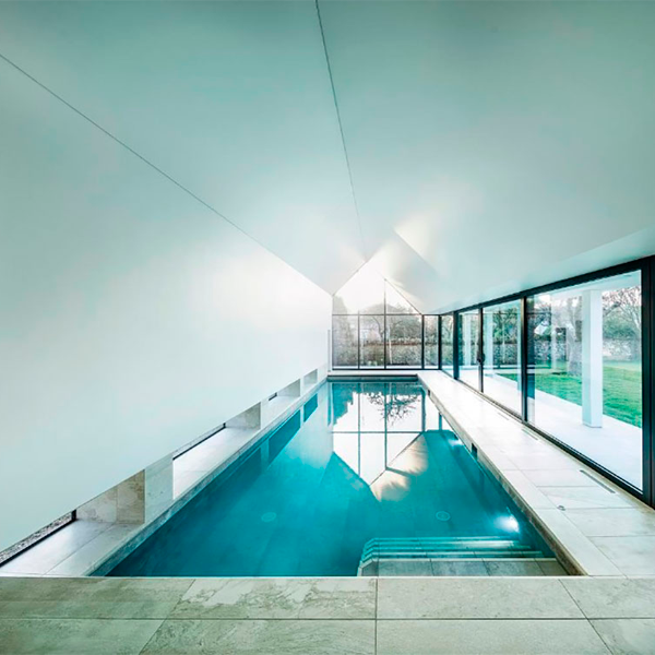 piscina interior con cristalera al jardín