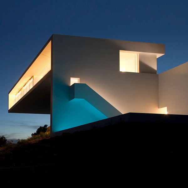 reflejo de iluminación piscina sobre pared de vivienda minimalista en color blanco