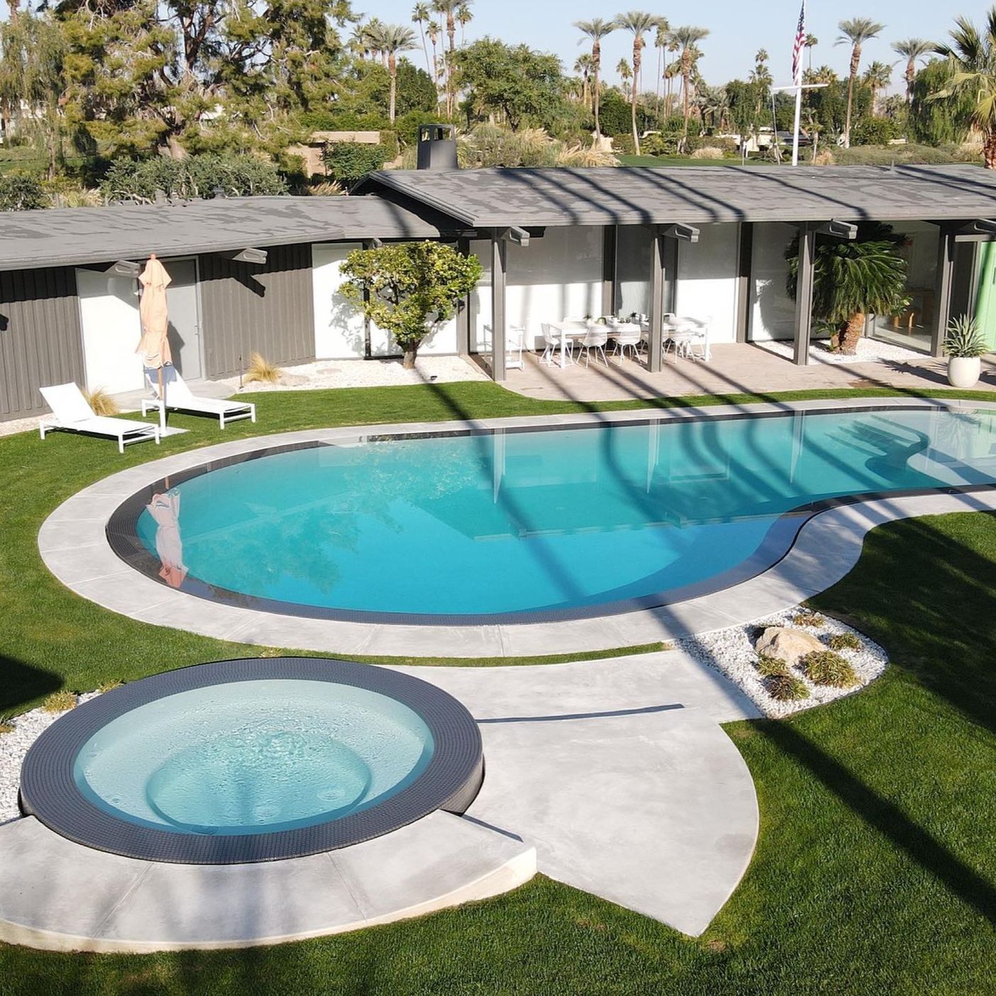 Custom overflow pool and freestanding spa, by MPS Builders, in a modern garden
