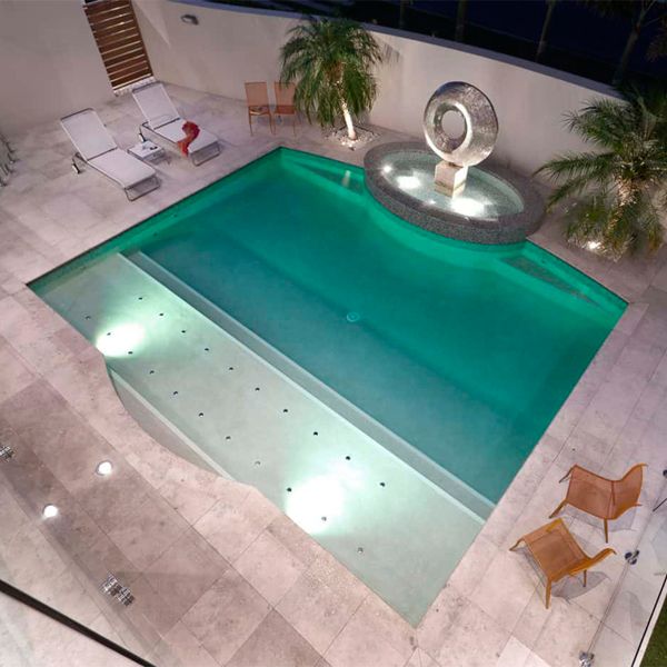 Luxury private pool with exclusive spa, illuminated at night in the backyard of a modern house, by Brian Burke Homes