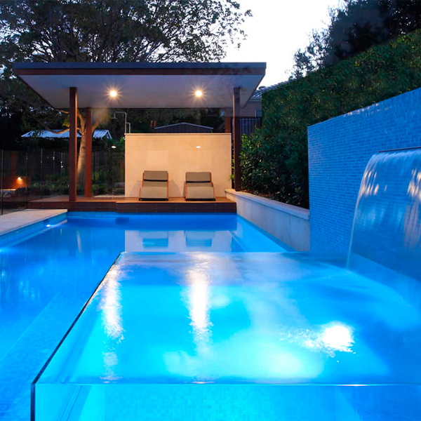 transparent spa overflowing a swimming pool