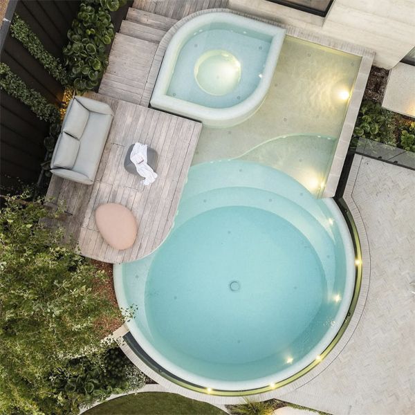 Drone view of a round infinity pool, by TLC Pools, in a spectacular and modern garden, also with an overflowing spa