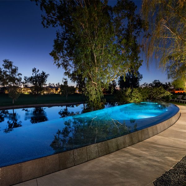 custom infinity pool and spa at night, by Liquid Evolution Pools