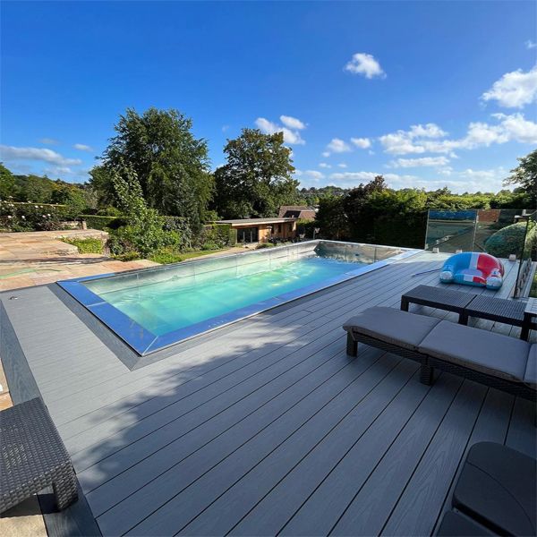 stainless steel pool rounded by synthetic wooden deck, in a landscaping project by Raze Roberts