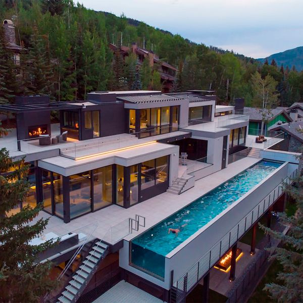 drone view of a stainless steel lap pool with transparent underwater window and floor, by Colorado Pool and Spa, in a modern industrial design house