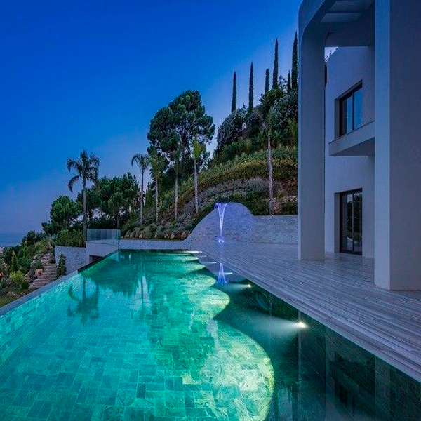 piscina desbordante en piedra volcánica por la noche