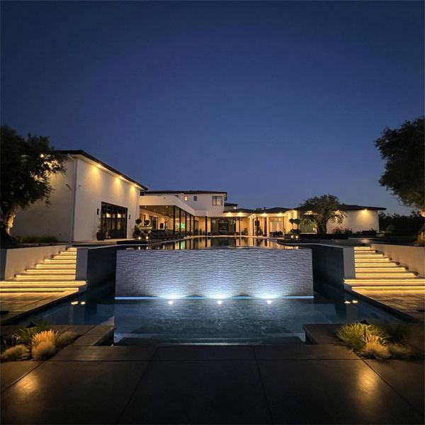 impressive mirror pool and spa at night, in a project by Cosgrove Custom Pools