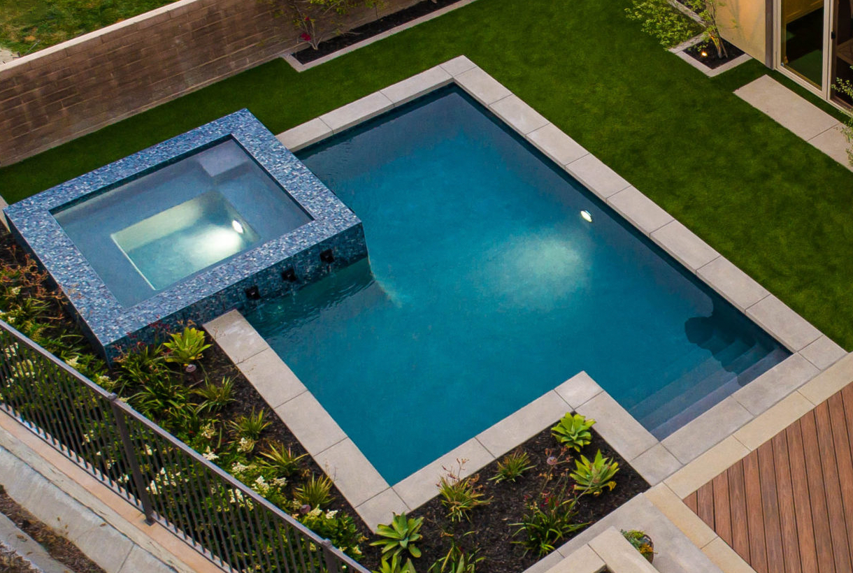 small pool with straight lines on a private plot with an overflowing spa next to it