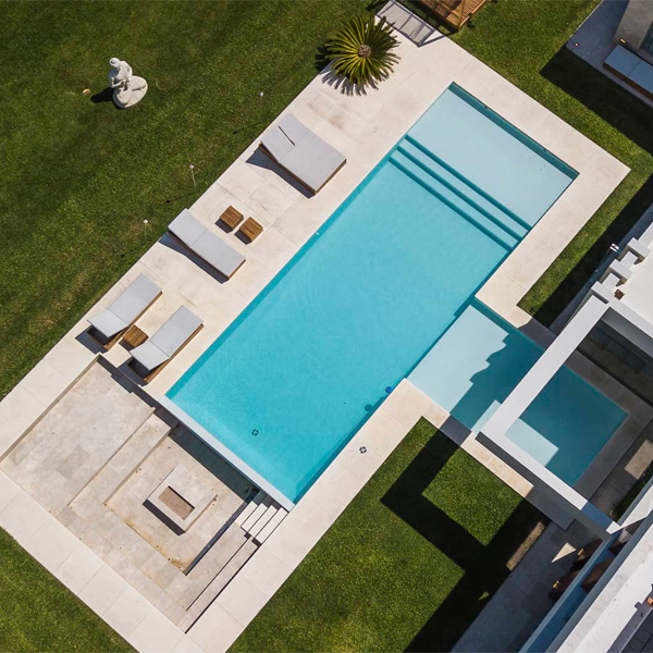 vista aérea de piscina rectangular clásica con zona de playa