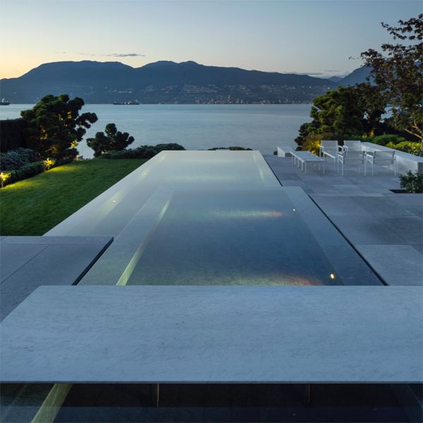 Espectacular piscina infinity con spa de diseño moderno y minimalista, al atardecer con vistas al mar, realizada por Alka Pool