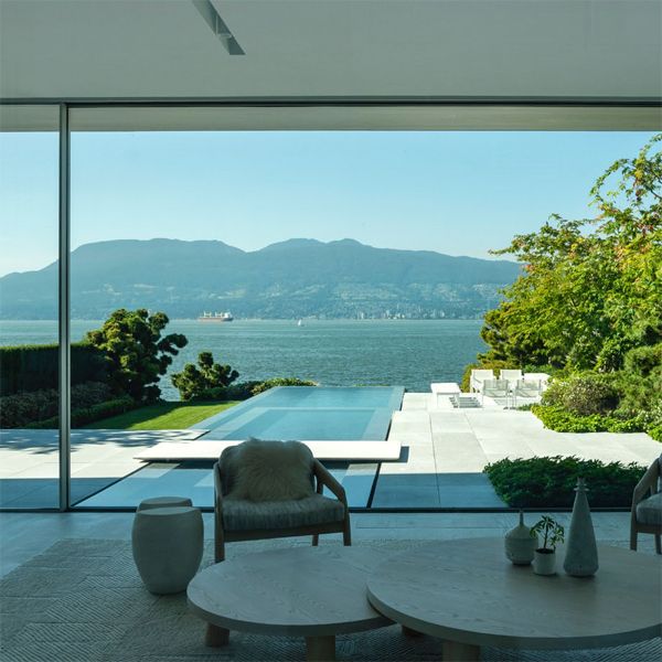 Espectacular piscina infinity con spa de diseño moderno y minimalista, vista desde el interior de la casa junto al mar, realizada por Alka Pool