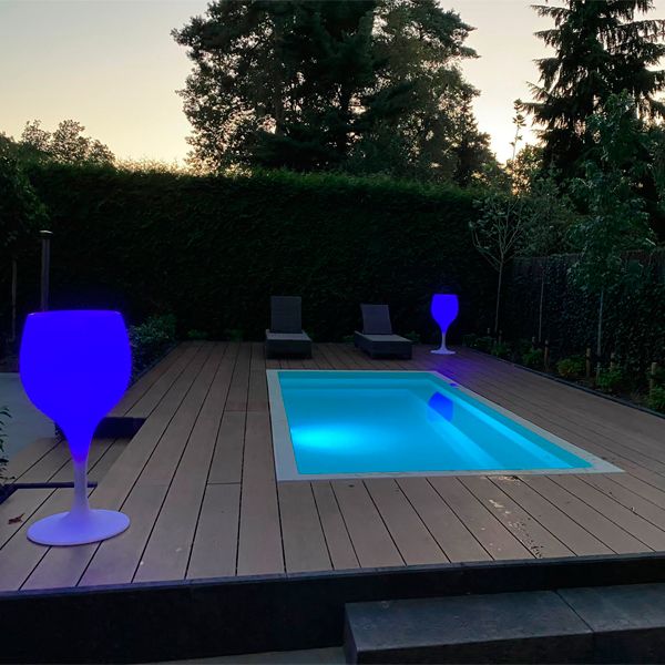mini piscina iluminada por la noche, em un jardín con tarima de madera, por Blaauw Mini Pools