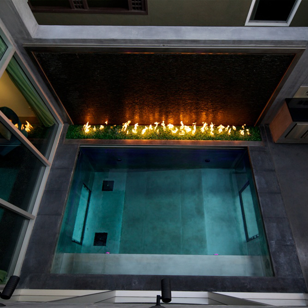 mini piscina de acero, con ventanas transparentes, junto aun espacio con fuego, en un proyecto de David Hertz Architects FAIA