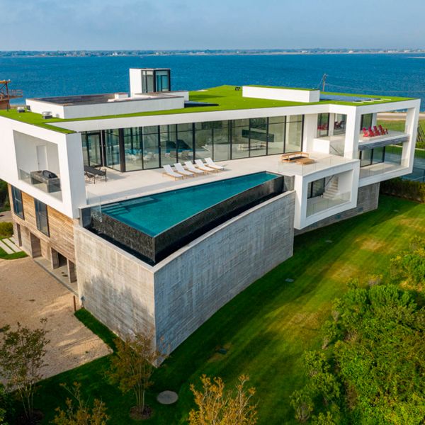 Vista dron de una espectacular piscina infinita en voladizo, en una casa de súper lujo, de diseño exclusivo, junto al mar, por DRPILLA