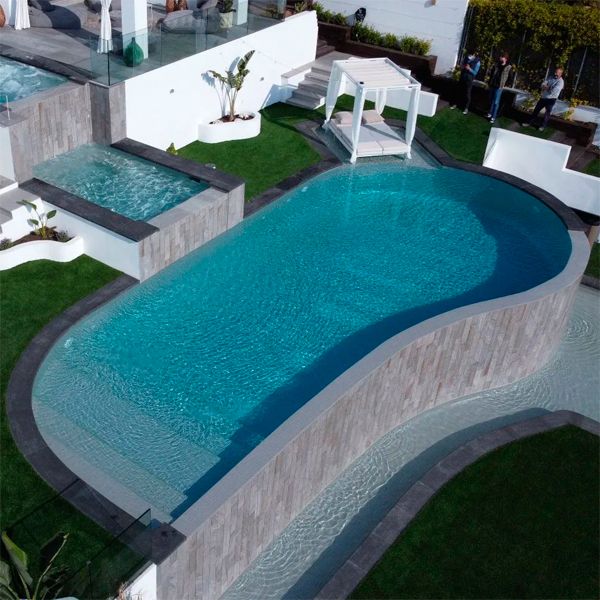 vista dron de una espectacular piscina infinity diseñada a 3 niveles, con spa integrado, por Exterior Piscines