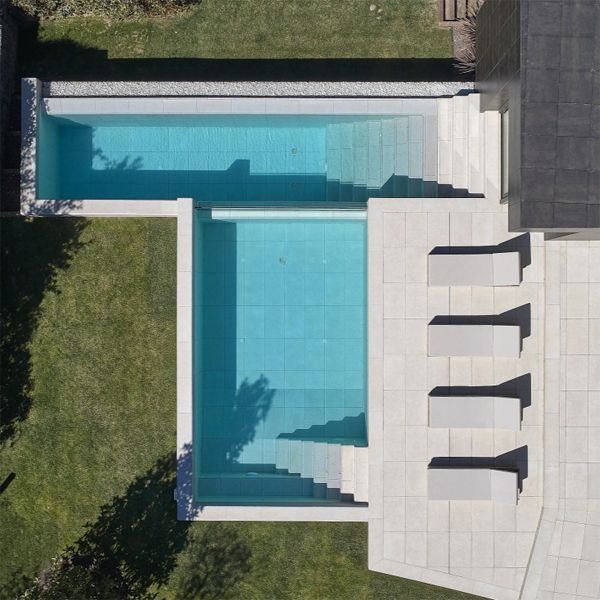 vista dron de piscina a medida a dos niveles, con una pared transparente, en proyecto de GAAB Arquitectes