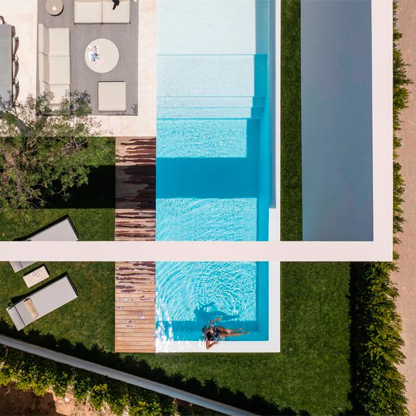 vista dron de piscina infinity minimalista de color blanco, en un proyecto moderno de Gallardo Llopis