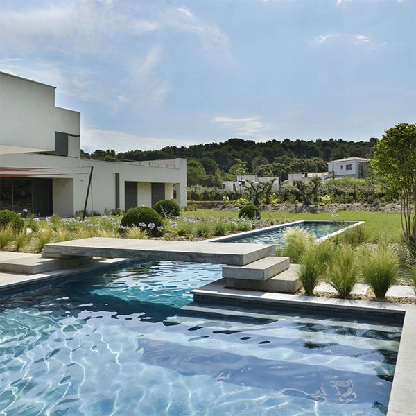 moderna piscina con carril de natación y espacio de descanso, en un proyecto de Piscines Jacques Brens