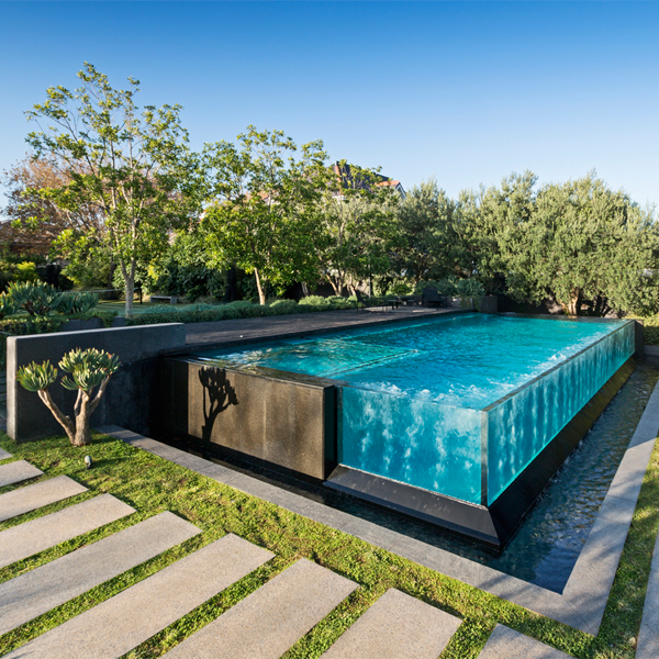 piscina infinity con pared transparente y spa incorporado, por Liquid Blue Pools