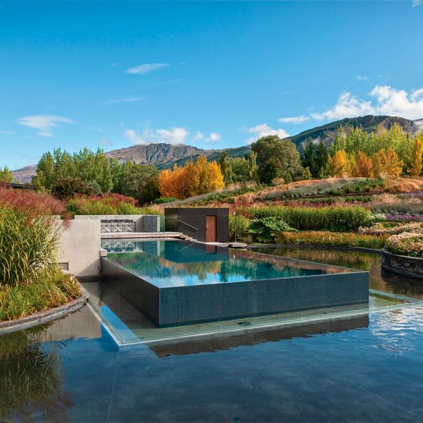 Piscina infinity, de diseño moderno y minimalista, sobre otra superficie de agua, en medio del campo, por Pionner Pools