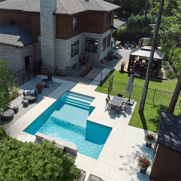 vista dron de una piscina privada a medida por Piscines Trevi, en un moderno jardín de una casa unifamiliar