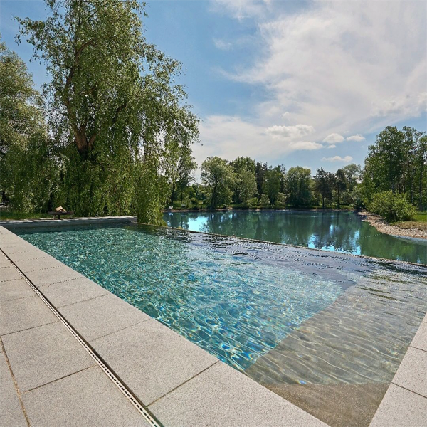 piscina infinity junto al lago por Thamm Schwimmbadtechnik