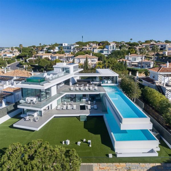 Vista dron de una increíble piscina infinita volada sobre otra piscina, dentro de un moderno y minimalista proyecto de Vasco Vieira Arquitectos