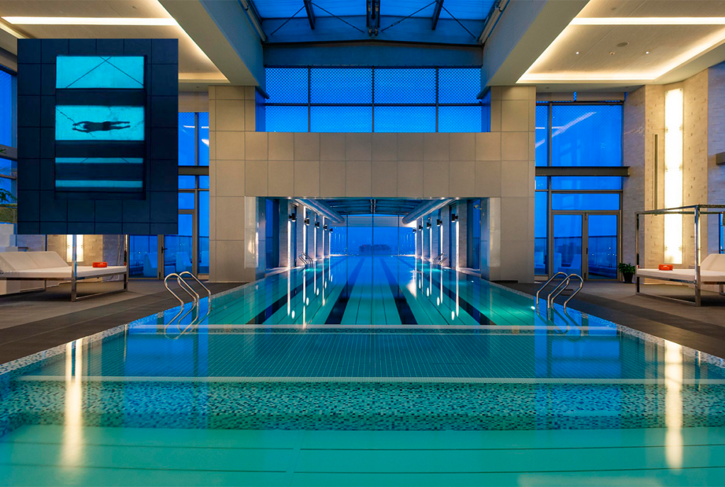 Vista interior de piscina de hotel con suelo transparente en un extremo