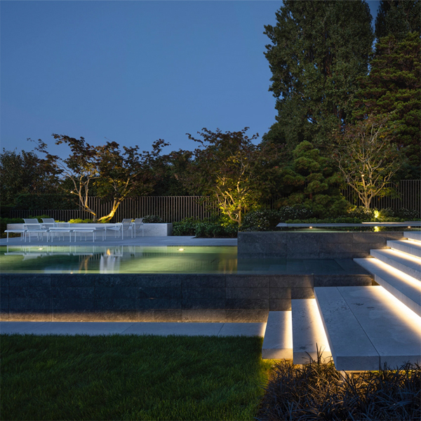 Espectacular piscina infinity con spa de diseño moderno y minimalista, por la noche, realizada por Alka Pool