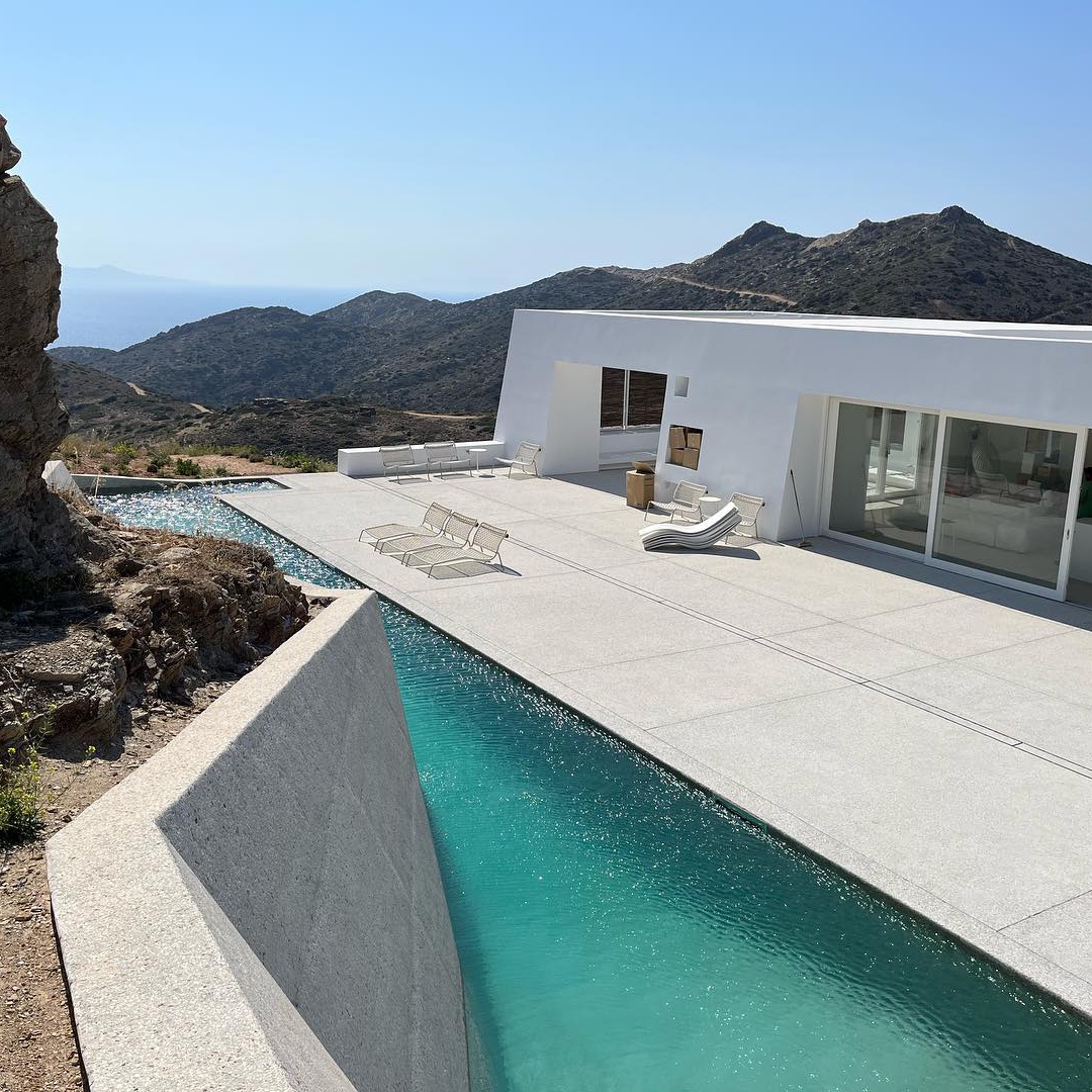 Vista aérea de piscina privada, estilo canal de natación, de diseño único y diferente junto a las rocas por Alpha Pools, en un espacio moderno y minimalista
