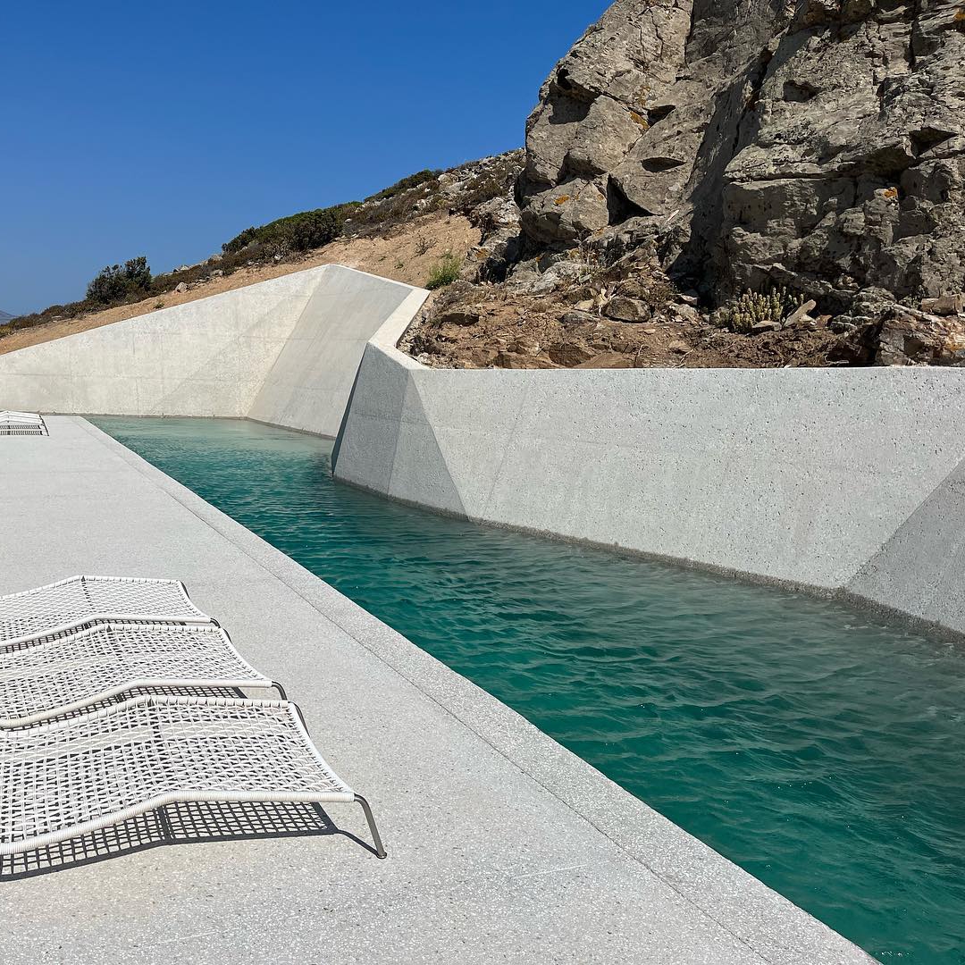 Piscina privada, estilo canal de natación, de diseño único y diferente junto a las rocas por Alpha Pools
