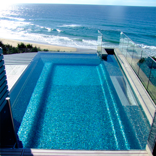 piscina transparente, tipo infinity, elevada sobre el suelo, con espectaculares vistas a la playa, por Aquatonic Architectre