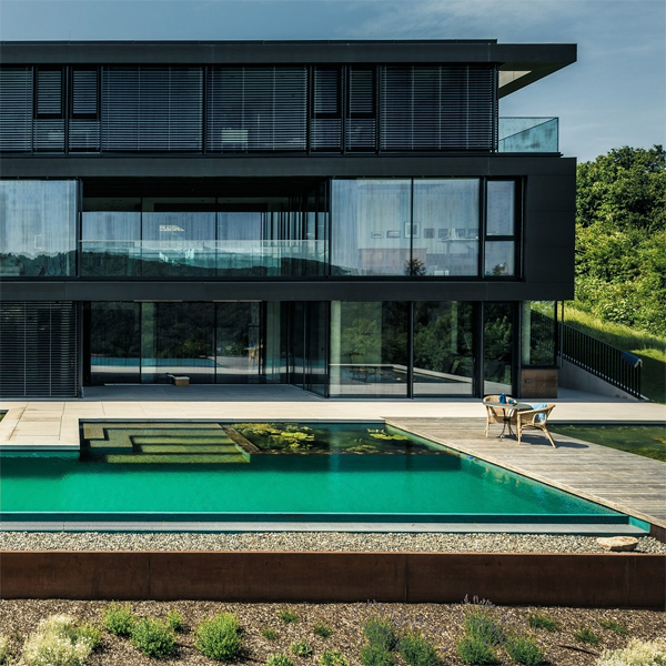 Vista dron de piscina natural tipo infinity, de Biotop, en casa de diseño moderno y minimalista