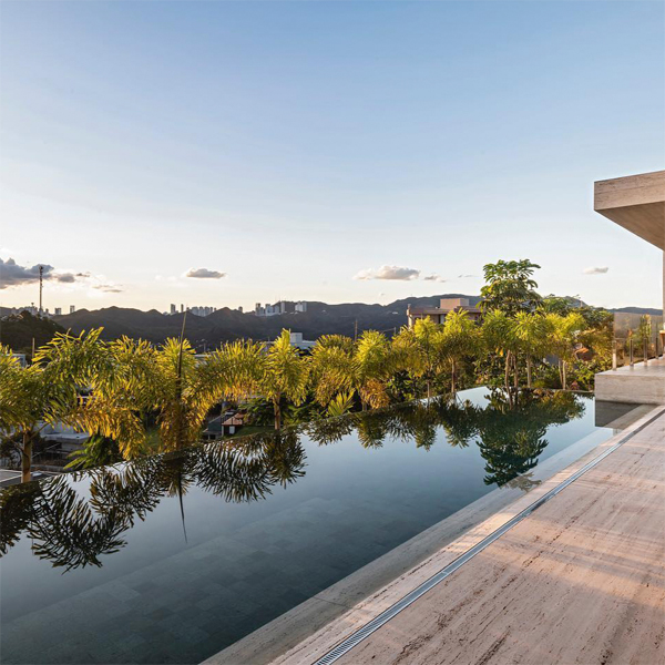 Piscina infinita de diseño minimalista, estilo canal de natación, en un proyecto de Boechat Casas, con espectaculares vistas al atardecer