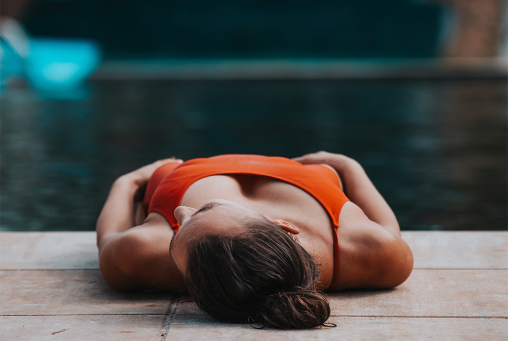 Mujer tumbada junto a una piscina con agua caliente