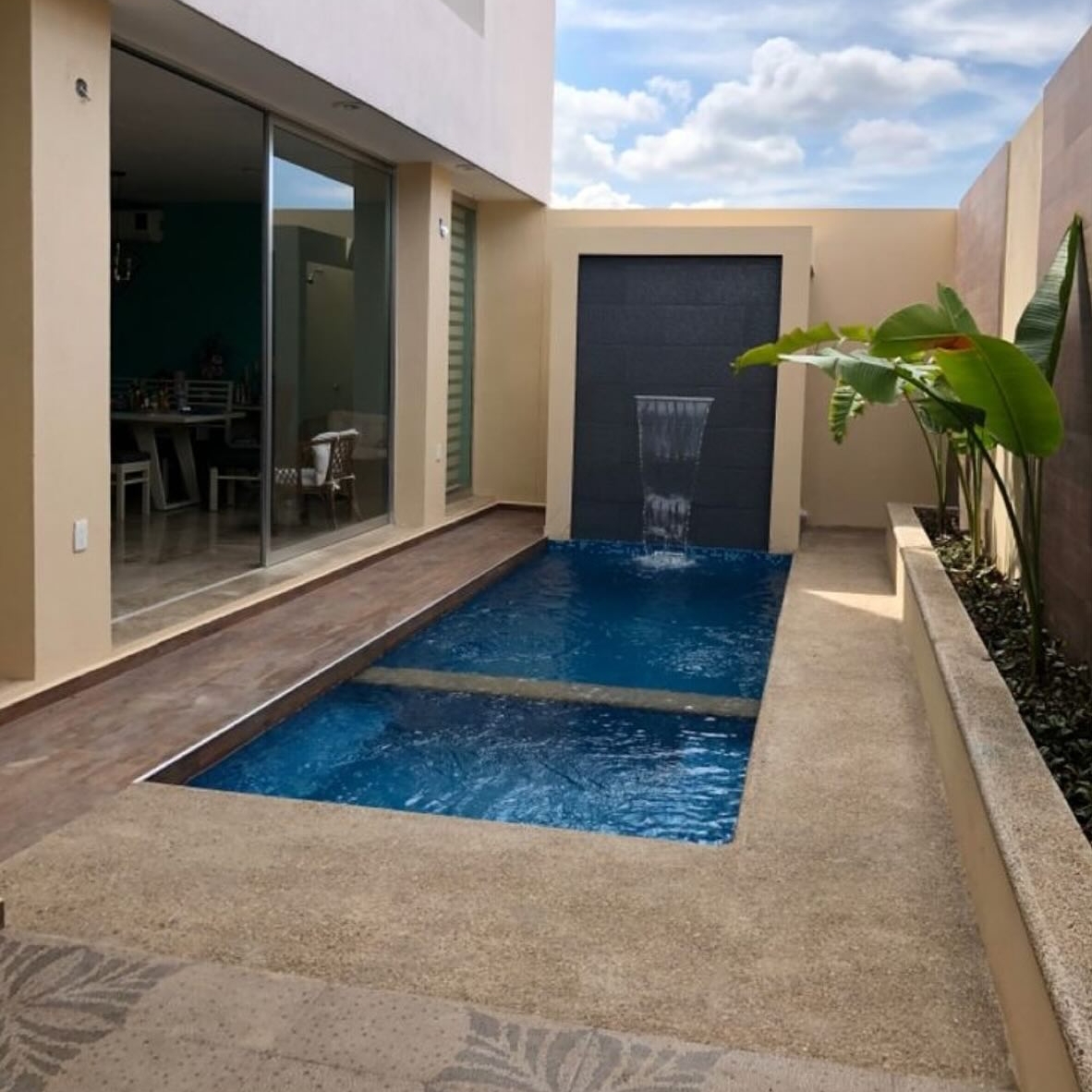 mini piscina de diseño minimalista, con spa integrada y cascada de pared, por Construpiscinas