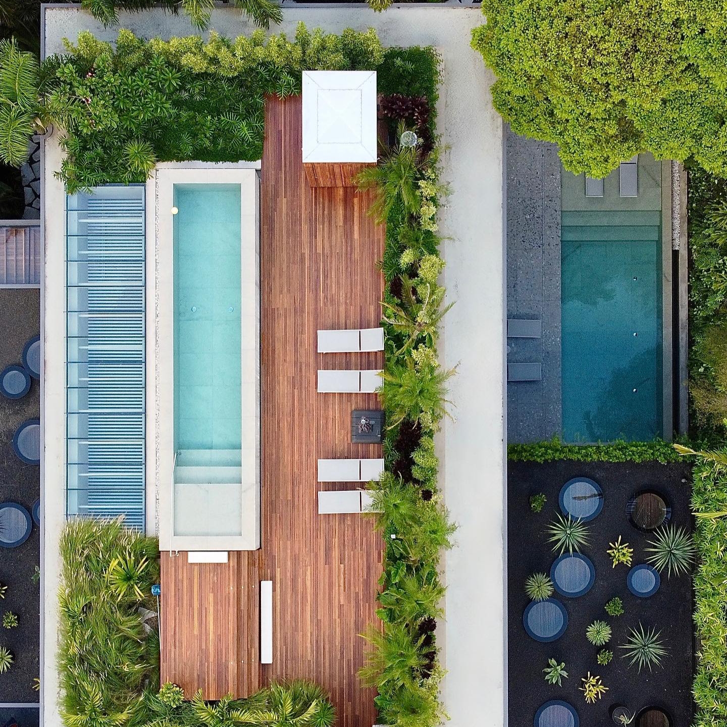 Vista dron de un proyecto espectacular de DB Arquitetos, con dos piscinas desbordantes de conceptos distintos, en un espacio moderno rodeado de vegetación