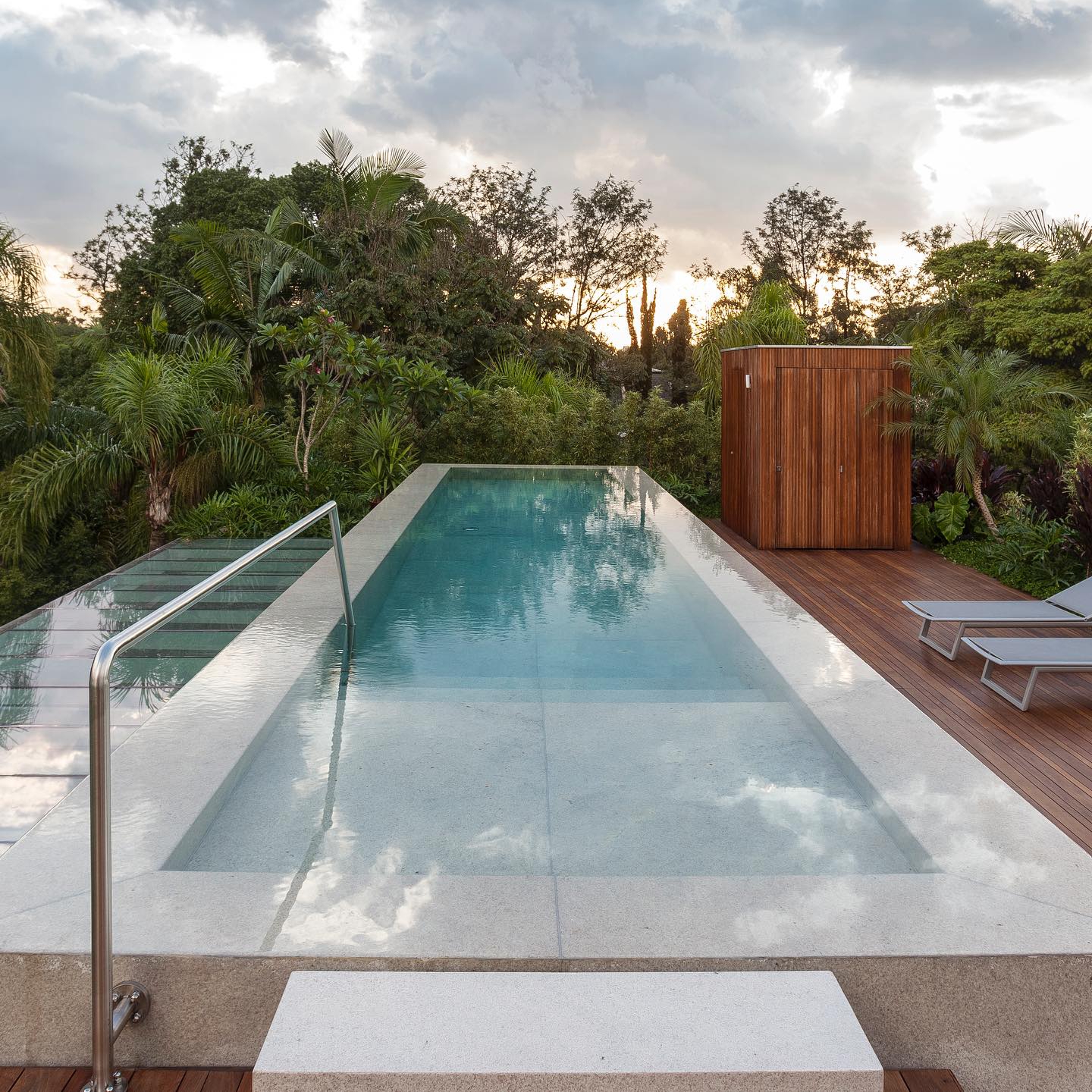 Elegante piscina infinita de diseño minimalista, en un proyecto de DB Arquitetos