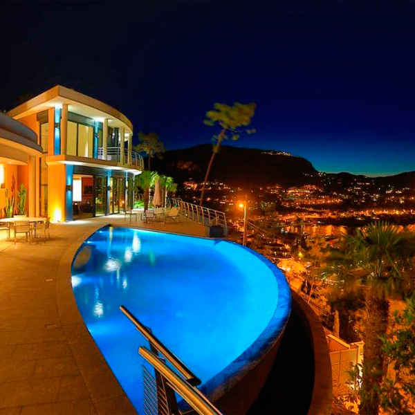Una piscina infinity única, iluminada por la noche, de Diffazur Piscines