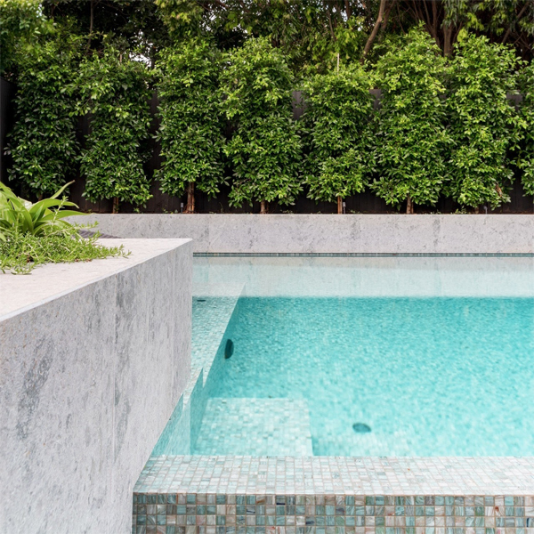 detalle de piscina infinita de Feature Pools, con una estupenda combinación de materiales como gresite de vidrio, piedra...